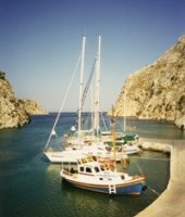 Bareboat charter yachts nestle in an inlet on the Clyclades islands, Greece